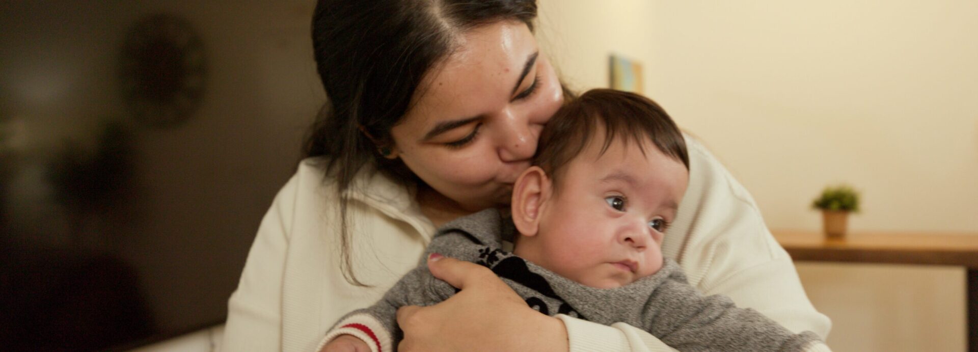 RMH BC & Yukon Mom kissing baby in Ronald McDonald Family Room at Surrey Memorial Hospital